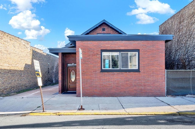 view of front facade with fence and brick siding