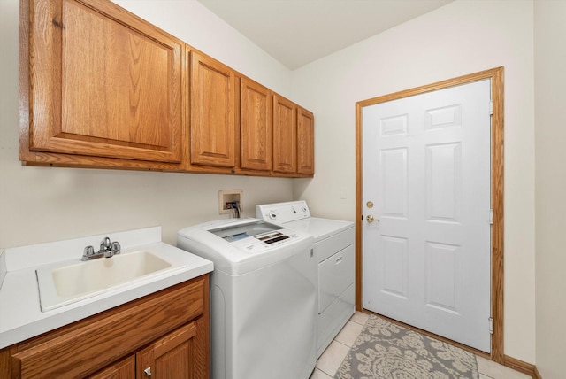 laundry room featuring washer and dryer, cabinet space, light tile patterned flooring, and a sink