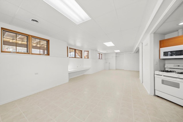 basement with a paneled ceiling and visible vents