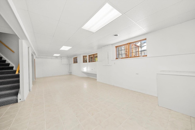 basement featuring stairway and a paneled ceiling