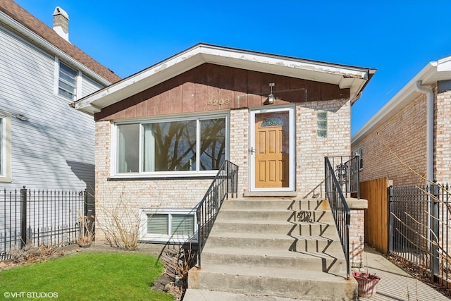 property entrance featuring brick siding and fence