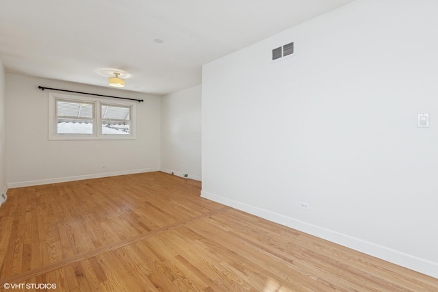 empty room with visible vents, baseboards, and light wood-style floors