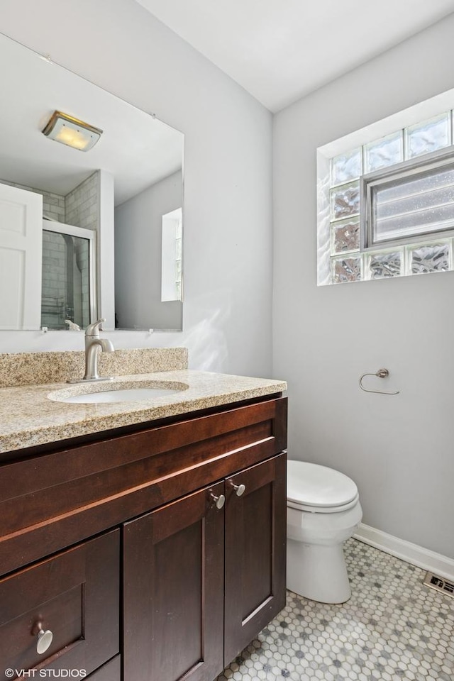 full bathroom featuring visible vents, toilet, a stall shower, baseboards, and vanity