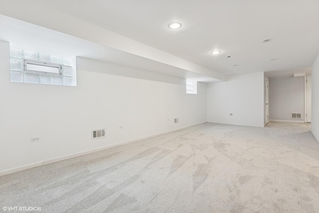 below grade area with light carpet, visible vents, recessed lighting, and baseboards