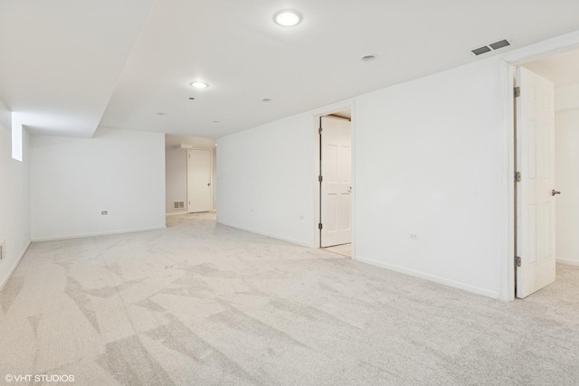 interior space featuring baseboards, visible vents, and light carpet