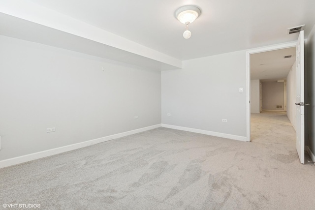 spare room with baseboards, visible vents, and light carpet