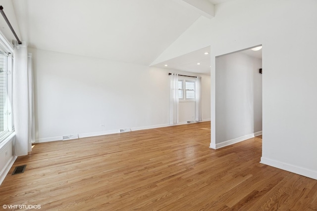 empty room featuring beamed ceiling, light wood-style flooring, visible vents, and baseboards