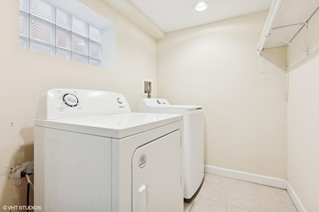 laundry area with washer and clothes dryer, laundry area, baseboards, and light tile patterned floors