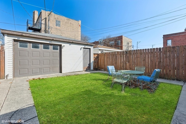 view of yard with an outbuilding, driveway, a garage, and fence