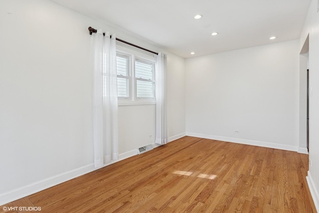 empty room featuring recessed lighting, visible vents, baseboards, and light wood finished floors