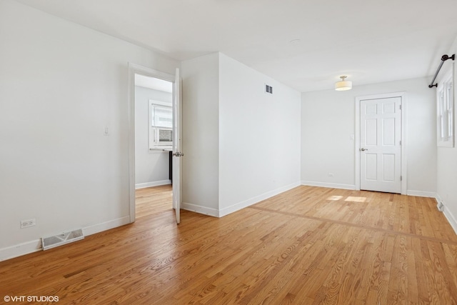 unfurnished room featuring visible vents, baseboards, and light wood finished floors