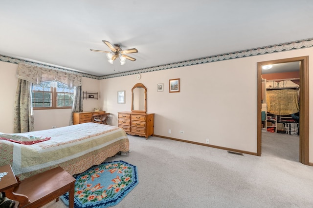 bedroom with visible vents, light colored carpet, a ceiling fan, and baseboards