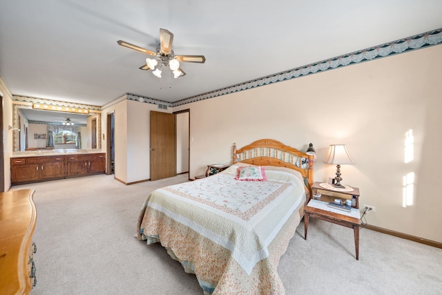 bedroom with a ceiling fan, light colored carpet, baseboards, and connected bathroom