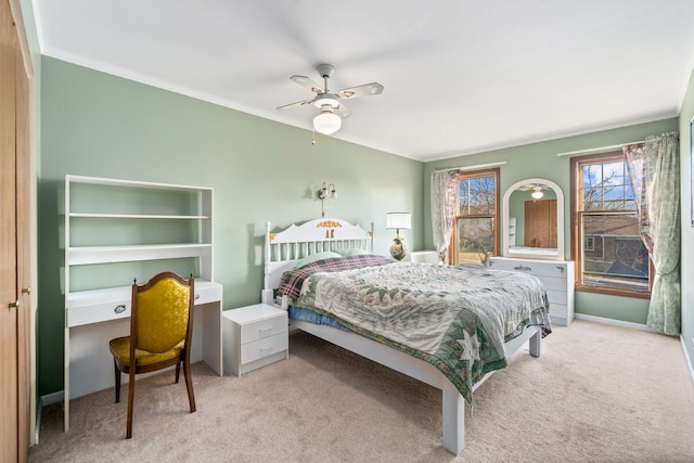 carpeted bedroom featuring a ceiling fan and ornamental molding