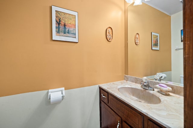 half bath featuring vanity and ornamental molding