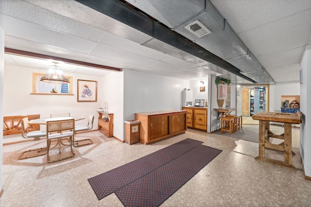 interior space with visible vents, a paneled ceiling, and baseboards