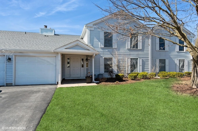 view of front of property with a front yard, roof with shingles, an attached garage, a chimney, and aphalt driveway