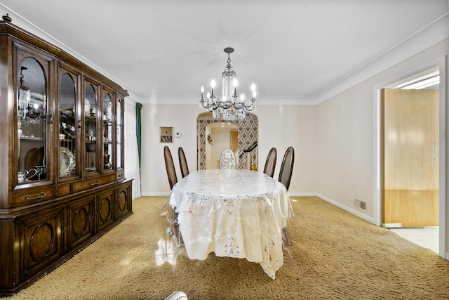 dining room featuring arched walkways, a chandelier, baseboards, and ornamental molding