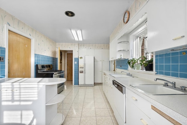 kitchen with wallpapered walls, white appliances, open shelves, and a sink