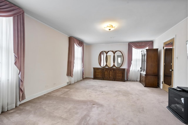 unfurnished bedroom featuring ornamental molding, baseboards, and carpet floors