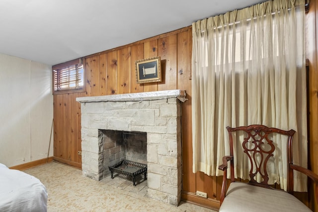 bedroom featuring carpet, wood walls, and a fireplace