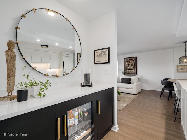 bar featuring baseboards, recessed lighting, light wood-type flooring, and pendant lighting