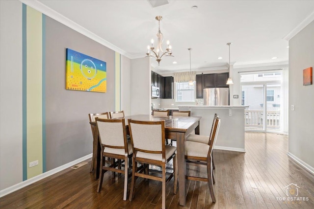 dining room featuring a chandelier, dark wood finished floors, baseboards, crown molding, and recessed lighting