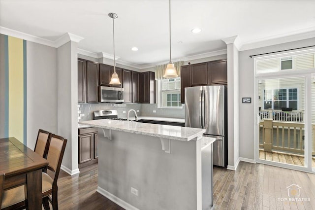 kitchen featuring stainless steel appliances, dark brown cabinetry, crown molding, dark wood-style floors, and backsplash