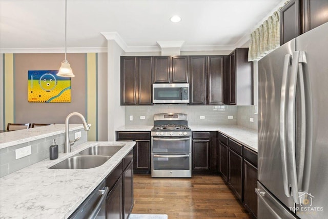 kitchen featuring stainless steel appliances, a sink, crown molding, dark wood-style flooring, and dark brown cabinetry