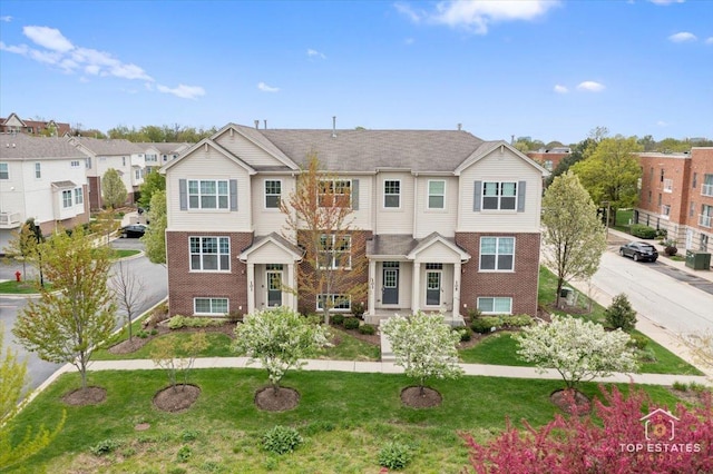 multi unit property with brick siding, a front yard, and a residential view