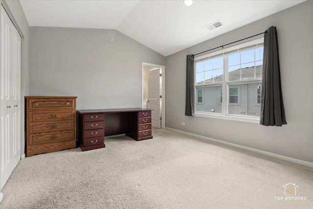 unfurnished bedroom featuring vaulted ceiling, a closet, light colored carpet, and baseboards