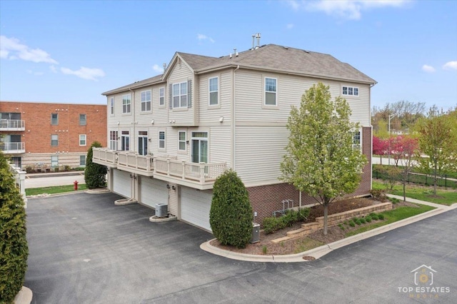 view of side of property with a garage, central AC, and driveway