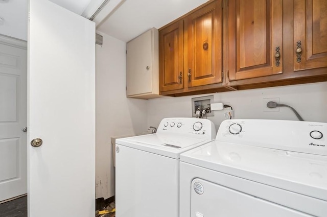 clothes washing area featuring washer and dryer and cabinet space