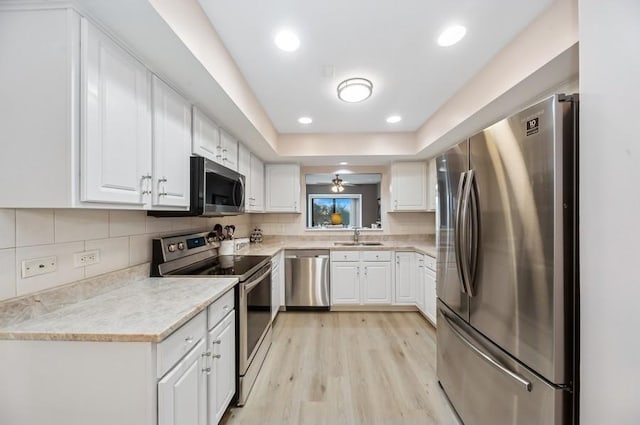 kitchen with decorative backsplash, stainless steel appliances, light countertops, and a sink