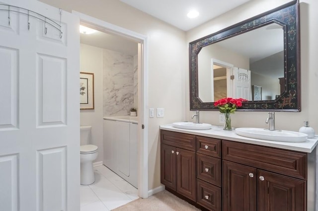 full bathroom with double vanity, toilet, and a sink