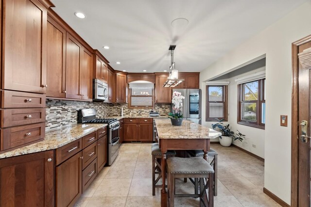 871 Woodcrest Ln, Lemont, IL 60439 - kitchen featuring appliances with stainless steel finishes, backsplash, light stone countertops, pendant lighting, and a kitchen island