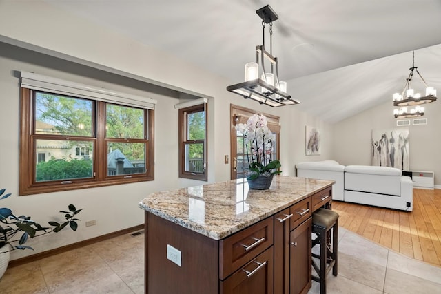 871 Woodcrest Ln, Lemont, IL 60439 - kitchen featuring a chandelier, light stone countertops, hanging light fixtures, baseboards, and a kitchen island