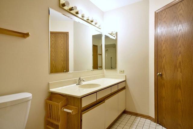 bathroom with vanity, tile patterned floors, toilet, and baseboards