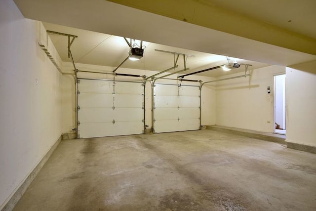 garage featuring a garage door opener and baseboards