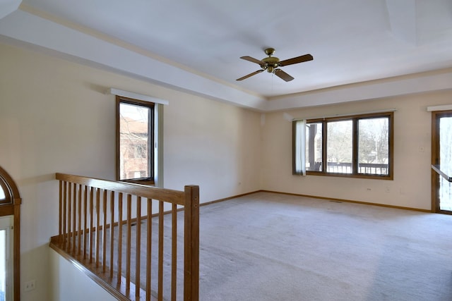 unfurnished room featuring baseboards, a wealth of natural light, and light carpet