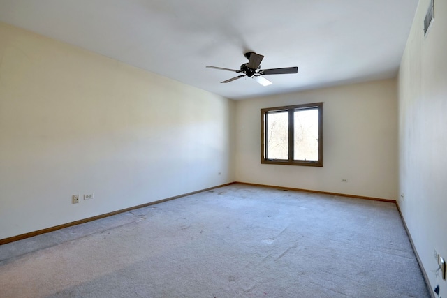 empty room featuring a ceiling fan, visible vents, baseboards, and light carpet