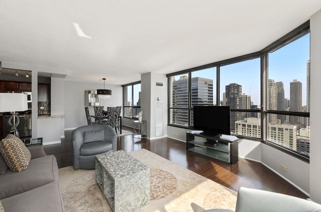 living area featuring baseboards, a notable chandelier, and wood finished floors