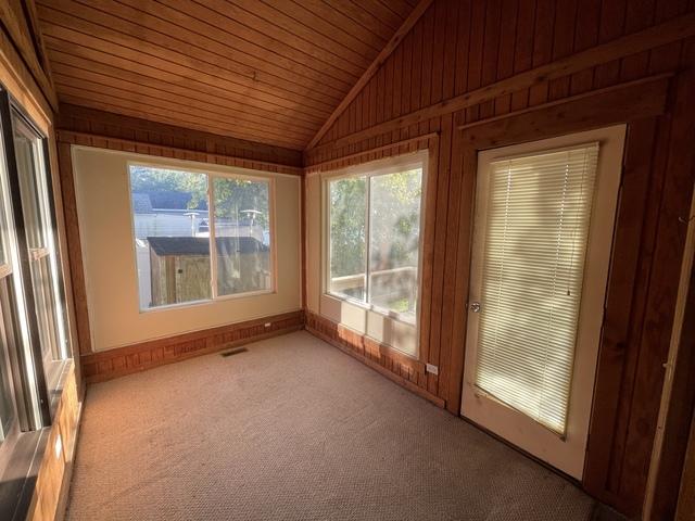 unfurnished sunroom with visible vents, wood ceiling, and vaulted ceiling