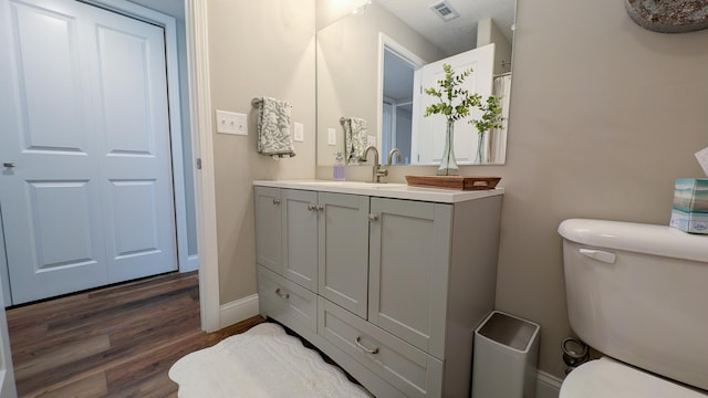 1617 Oliger Dr, Mahomet, IL 61853 - full bathroom with visible vents, baseboards, toilet, wood finished floors, and vanity