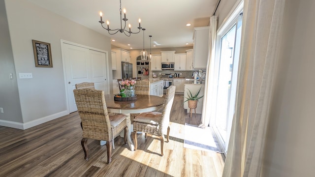 1617 Oliger Dr, Mahomet, IL 61853 - dining area with a wealth of natural light, baseboards, an inviting chandelier, and wood finished floors