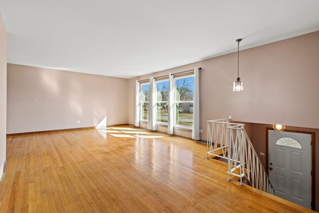 unfurnished living room featuring light wood-type flooring and baseboards