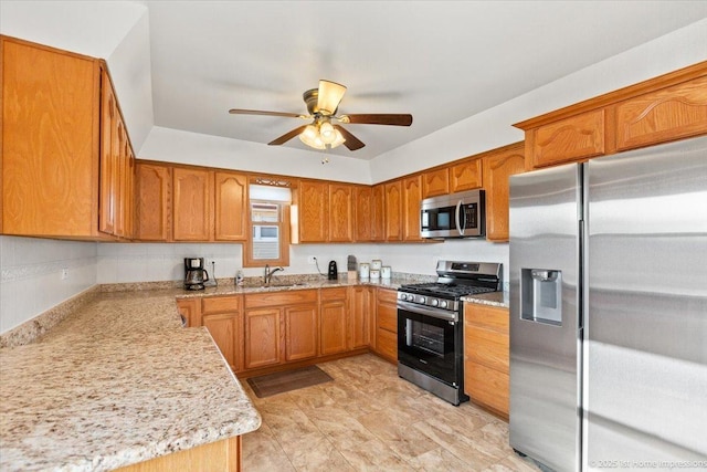 kitchen featuring brown cabinetry, appliances with stainless steel finishes, and a sink