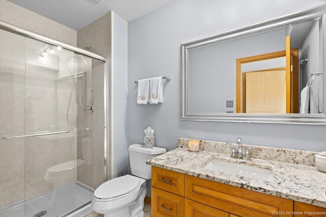 bathroom featuring vanity, toilet, and a stall shower