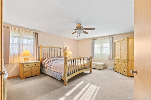 bedroom with baseboards, carpet floors, visible vents, and a ceiling fan