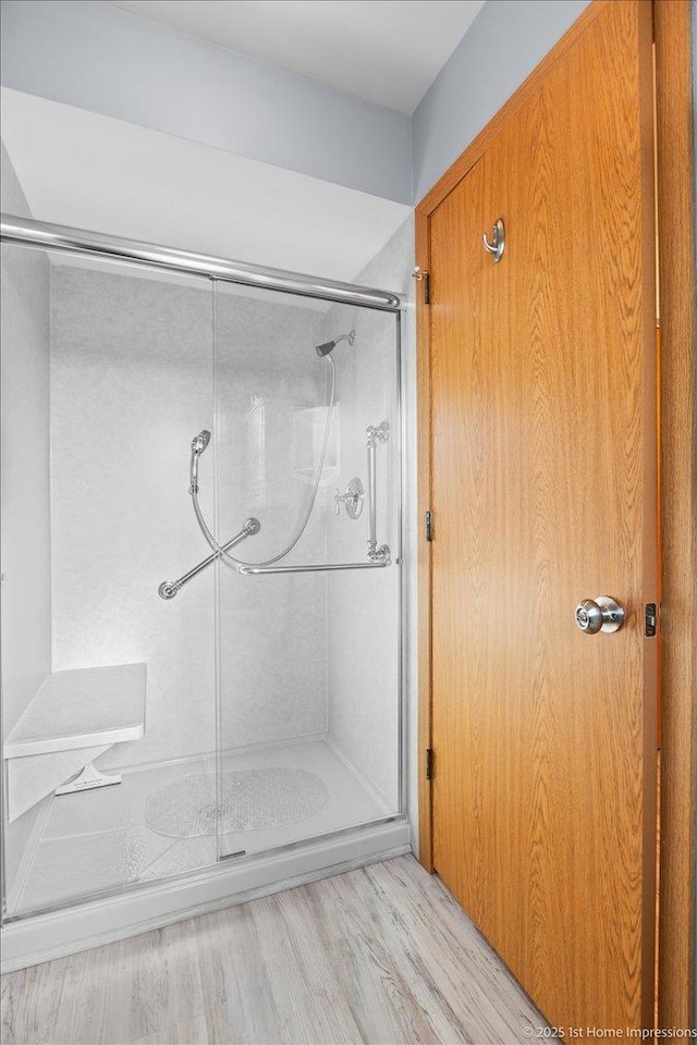 full bathroom with a shower stall and wood finished floors